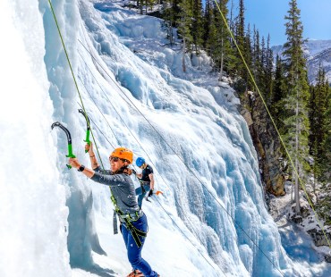 Person climbing up the Frozen ice at Tangle Falls Person climbing up the Frozen ice at Tangle Falls