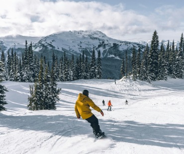 Snowboarder cruising down run at Whistler Blackcomb Snowboarder cruising down run at Whistler Blackcomb