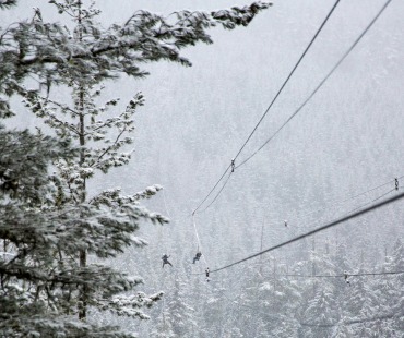 People flying on ziplines at Whistler in the winter People flying on ziplines at Whistler in the winter