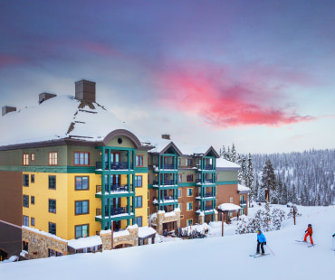 ski in ski out lodging and skiers going past ski in ski out lodging and skiers going past