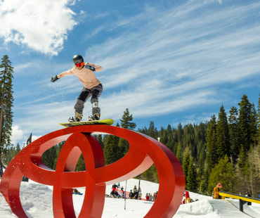 Snowboarder grinding on the toyota symbol rail Snowboarder grinding on the toyota symbol rail