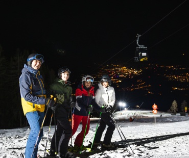 people on the slopes with city lights in the background people on the slopes with city lights in the background