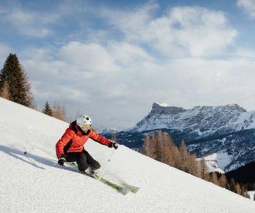 Skier carving through snow covered back country Skier carving through snow covered back country