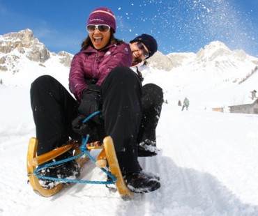 People racing down trails on sled People racing down trails on sled
