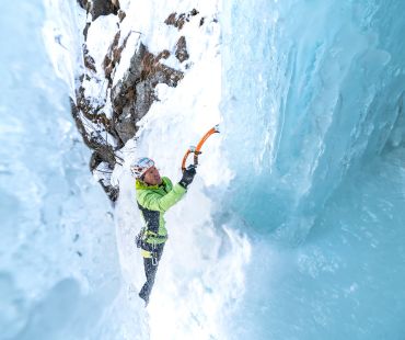 Man climbing steep frozen waterfall Man climbing steep frozen waterfall
