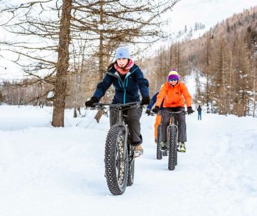 People fat biking through snow covered trails People fat biking through snow covered trails