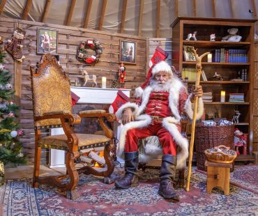 Santa sitting in christmas village Santa sitting in christmas village