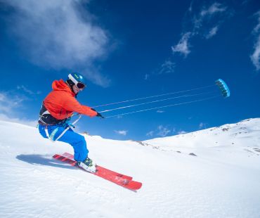 Person catching wind with sails on skis Person catching wind with sails on skis