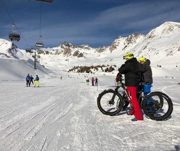 People on fatbikes watching skiers on trails People on fatbikes watching skiers on trails