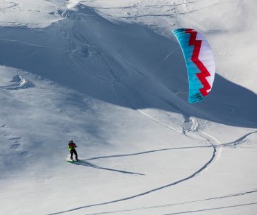 Snowboarder using a snow kite on the hill Snowboarder using a snow kite on the hill