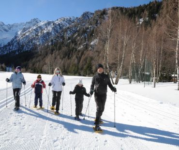 Family walking in snowshoes on snowy trails Family walking in snowshoes on snowy trails