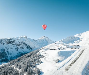 Red Hot air ballon high over the snowy mountains Red Hot air ballon high over the snowy mountains