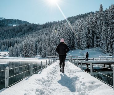 Person hiking over snowy bridge Person hiking over snowy bridge