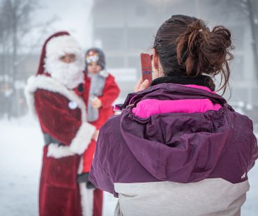 Person taking picture of child with Santa Person taking picture of child with Santa