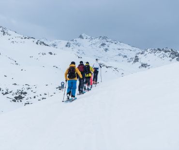 People hiking up the mountain in skis People hiking up the mountain in skis