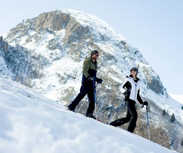People hiking on snowy hills in snowshoes People hiking on snowy hills in snowshoes
